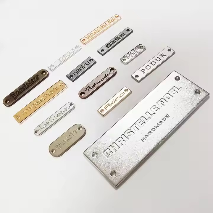 Close-up of custom-designed 3D engraved metal tags featuring detailed brand logos
