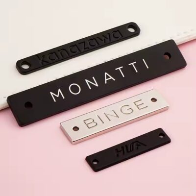 Custom engraved metal tags on swimwear with clear branding and design


