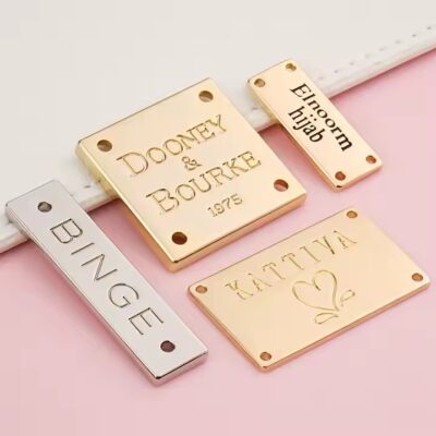 Custom engraved metal tags on swimwear with clear branding and design

