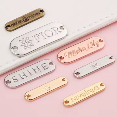 Custom engraved metal tags on swimwear with clear branding and design

