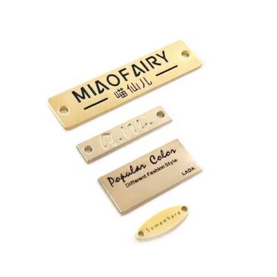 Close-up of custom square-shaped metal tags engraved with letters for branding