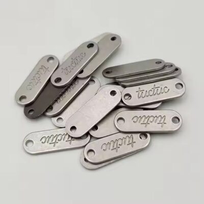 Custom metal tags with engraved brand names for fashion accessories