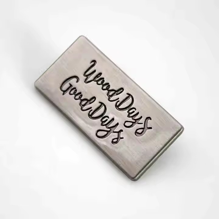 Custom metal tags with engraved brand names for fashion accessories