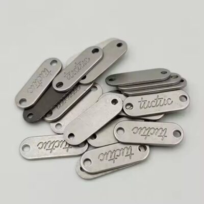 Custom metal tags with engraved brand names for fashion accessories
