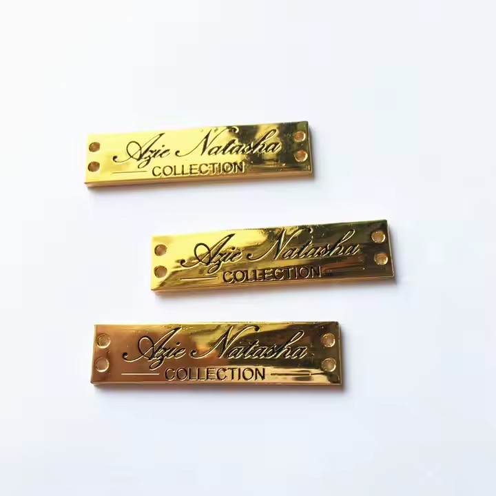 Close-up of stylish engraved metal tags designed for fashion apparel branding