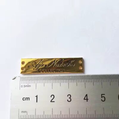 Close-up of stylish engraved metal tags designed for fashion apparel branding