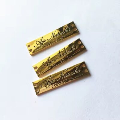 Close-up of stylish engraved metal tags designed for fashion apparel branding