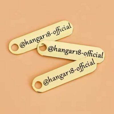 Stylish engraved metal tags attached to fashionable clothing items