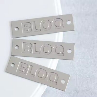 Stylish engraved metal tags attached to fashionable clothing items